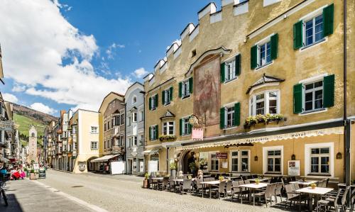 a street in a town with tables and chairs at Hotel Restaurant Lilie in Vipiteno