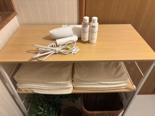 a wooden shelf with towels and products on it at 民泊浜田 蛍の里 in Hamada