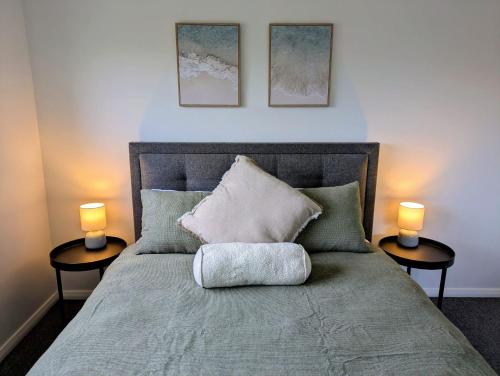 Un dormitorio con una cama con dos lámparas encima. en Blue Palms Cottage, en North Haven