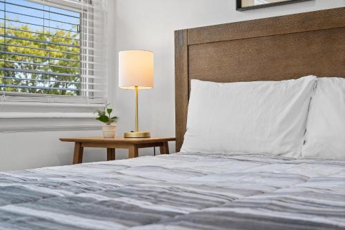 a bedroom with a bed and a table with a lamp at Pittsburgh Shadyside 3A Bright and Stylish Private Bedroom with Shared Bathroom in Pittsburgh
