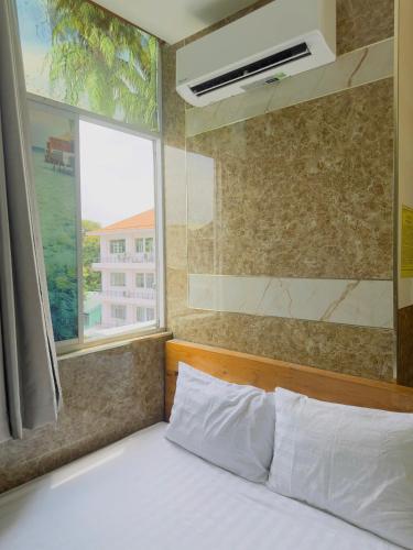 una cama en una habitación con ventana y una cama sidx sidx en Khách sạn Thế Giới Mới - Thế Giới Mới Hotel, en Ho Chi Minh