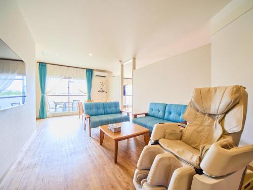 a living room with two chairs and a couch at ライカムファミリーリゾートホテル旧HiyagunLanaiResort in Okinawa City