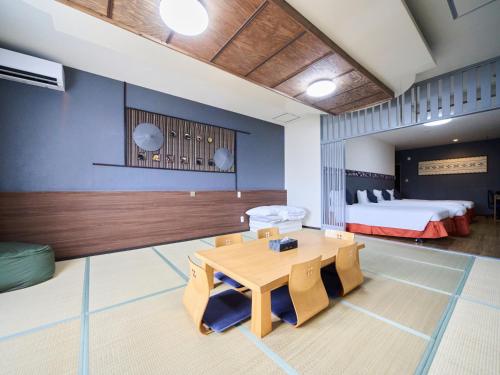 a room with a table and a bed at ライカムファミリーリゾートホテル旧HiyagunLanaiResort in Okinawa City
