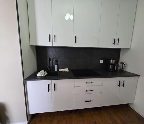 a kitchen with white cabinets and a black counter top at Ger buudal Orkhon in Erdenet