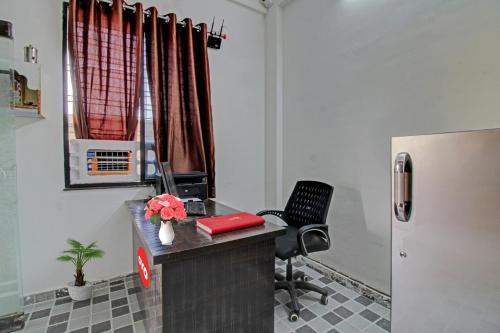 an office with a desk and a chair and a refrigerator at Hotel O Dhurva Inn in Nagpur