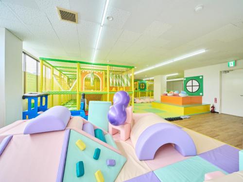 a childrens play room with a slide and a playground at Rycom Family Resort Hotel in Okinawa City