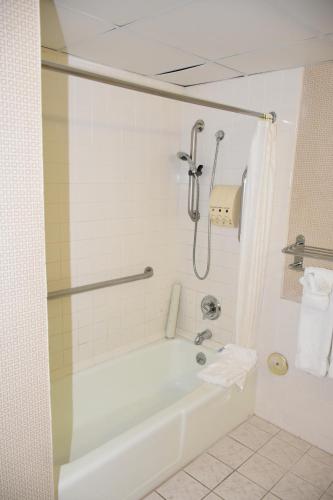 a bathroom with a white tub and a shower at Ontario Airport Inn in Ontario