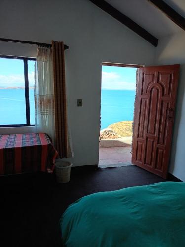 a bedroom with a door and a view of the ocean at Ecolodge El descanso in Comunidad Yumani