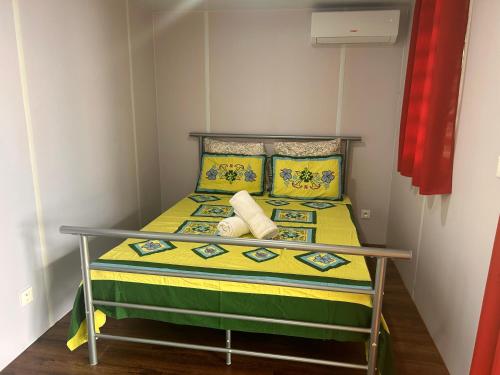a small bedroom with a bed with yellow and green at MOOREA - Bungalow Nauhei Surf Spot 1 in Haapiti