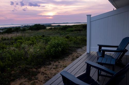 a deck with two chairs and a table on it at Dune Crest Hotel in North Truro