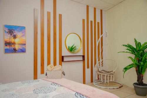 1 dormitorio con cama, espejo y planta en Casa Sto Tomas, en Puerto Santo Tomás de Castilla