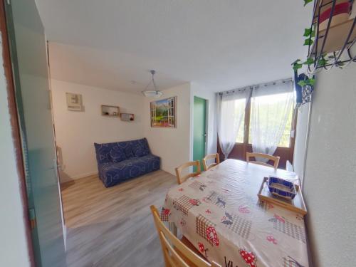 a room with a table and chairs and a couch at Location 4 pers., proche centre Les Rousses, 1 chambre - FR-1-834-10 in Les Rousses