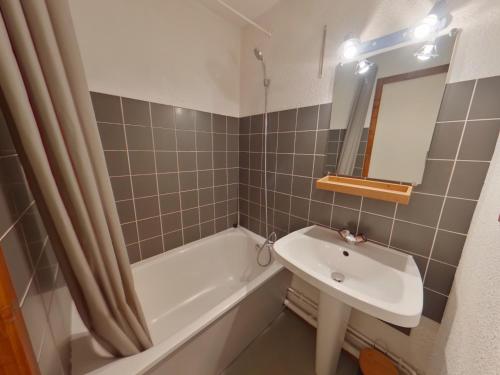 a bathroom with a sink and a bath tub and a mirror at Location 4 pers., proche centre Les Rousses, 1 chambre - FR-1-834-10 in Les Rousses