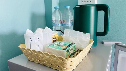 een mand met boodschappen op een aanrecht met waterflesjes bij เอ็นแอนด์พี รีสอร์ทบุรีรัมย์ in Ban Don Wai