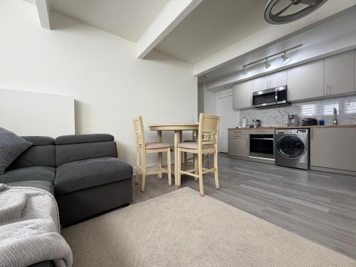 フェデラルウェイにあるGuest apartments The Comfy Nestのソファとテーブルとキッチンのあるリビングルーム