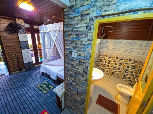 a bathroom with a stone wall and a shower at Ella Happy View Homestay in Ella