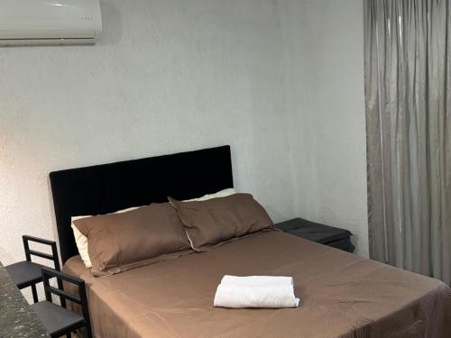 - un lit avec une serviette blanche dans l'établissement Apartamento aconchegante na Praia de Piratininga em Niterói, à Niterói