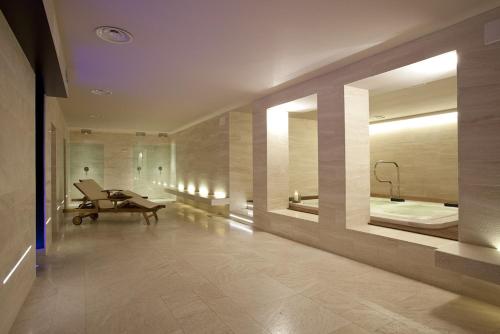 La grande salle de bains est pourvue d'un bureau et d'un miroir. dans l'établissement Terme di Acquasanta Hotel Italia & Spa, à Acquasanta Terme
