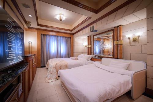 a hotel room with two beds and a flat screen tv at Hotel Grand Garden (Adult Only) in Yokohama
