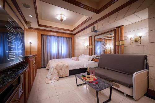 a hotel room with a bed and a television at Hotel Grand Garden (Adult Only) in Yokohama