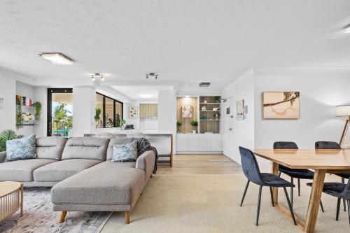 a living room with a couch and a table at Burgess @ Kings Beach Apartments in Caloundra