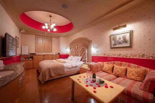 a living room with a bed and a couch at Hotel Grand Garden (Adult Only) in Yokohama