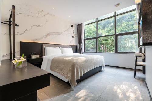 広州市にあるMankalun Hotelの大きなベッドと大きな窓のある寝室