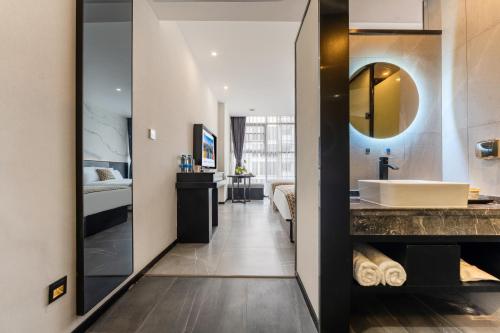 広州市にあるMankalun Hotelの部屋に浴槽と洗面台があるバスルーム