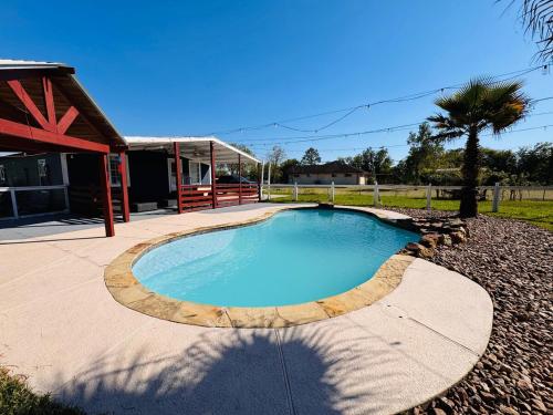a small swimming pool in a yard next to a house at The Blue Oasis - Palm & Pool Retreat in Pearland