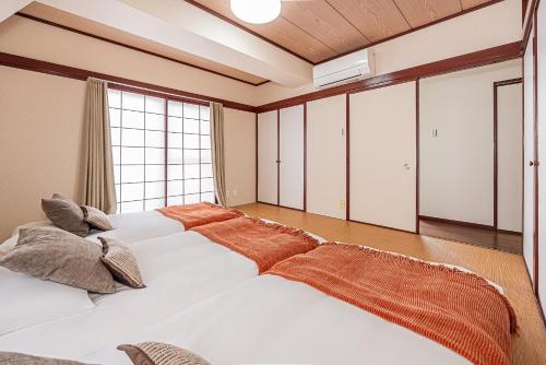 a bedroom with two beds and a large window at Mi-APT Kitashinjuku in Tokyo