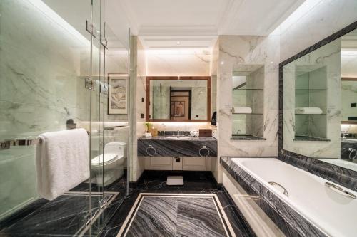 a bathroom with a tub and a sink at Howard Johnson Plaza Ningbo in Ningbo