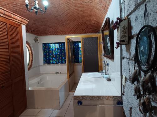 a bathroom with a tub and a sink and a bath tub at Villa Colibri in Tequisquiapan