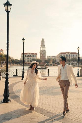 a man and a woman walking down a street at Golden Mountain Hotel Phu Quoc in Phú Quốc