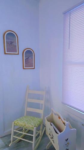 Habitación con mecedora y ventana en the paradise house 10 minutes from the beach, en North Rose