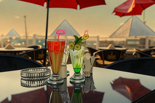 two glasses sitting on a table with an umbrella at 3 PYRAMiDS HUT HOTEL in Cairo