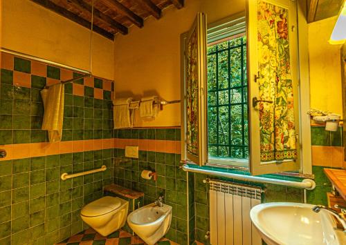 a bathroom with a sink and a toilet and a window at Agriturismo Settesoldi in San Miniato