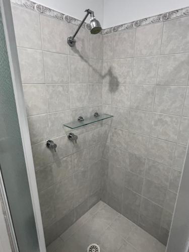 a shower with a glass shelf in a bathroom at Double room with shared bathoom in Auburn