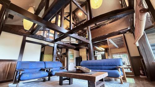 a living room with blue chairs and a table at 天空のお宿 雅館 in Ichinoseki
