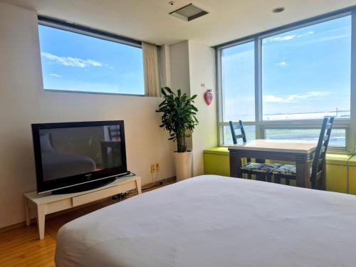 a bedroom with a bed and a tv and a table at Cozy - Experience Home like Comfort Studio in Incheon