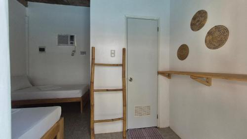 1 dormitorio con litera y escalera junto a una puerta en Camotes Hostel Resort, en Islas Camotes