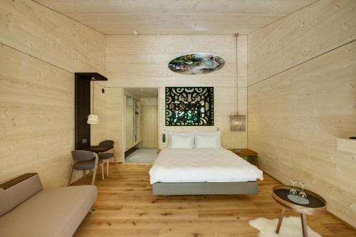 a bedroom with a bed and a couch at Hotel Rovanada Wellness & BergNatur in Vals