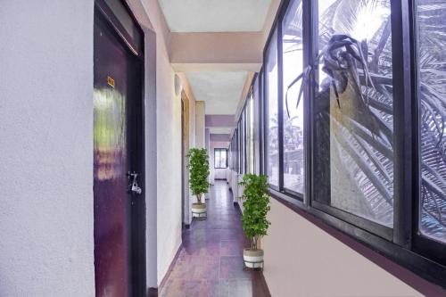 un couloir avec des plantes en pot et une porte dans l'établissement Hotel O Casa De Cajino Palace, à Calangute