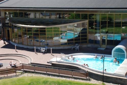 a swimming pool in front of a building with people in it at Finlandia Hotel Imatran Kylpylä Spa in Imatra