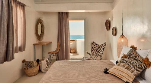 a bedroom with a bed and a view of the ocean at Naxian On The Beach in Plaka