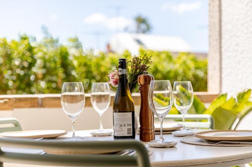 a table with glasses and a bottle of wine at Stylish and perfectly located Bondi Beach hideaway in Sydney