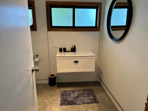 a bathroom with a sink and a mirror at Saturn Sands - 30 Saturn Parade in Venus Bay