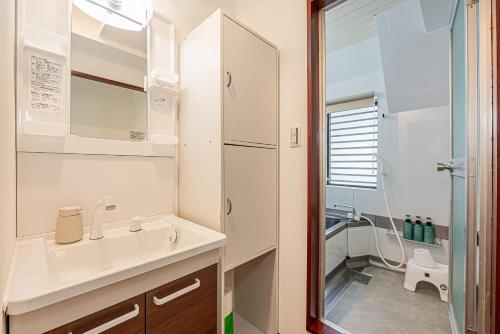 a white bathroom with a sink and a shower at Mi-APT Kitashinjuku in Tokyo
