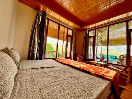 um quarto com uma cama grande e uma janela grande em Sharika Homes em Katrain