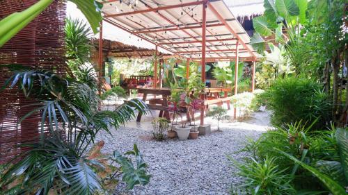 a garden with a patio with a lot of plants at Ilakai Hostel in General Luna
