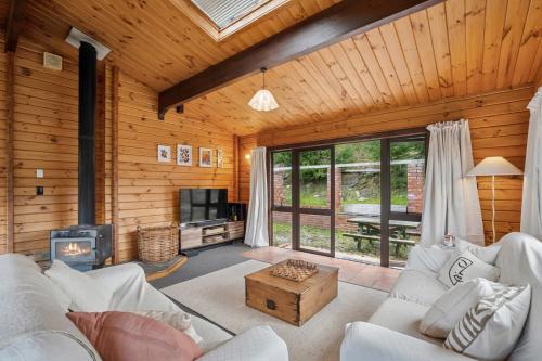 a living room with white furniture and a fireplace at Family-Friendly Chalet Mountain Views in Frankton Wharf